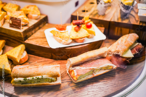 A selection of Spanish tapas including sandwiches and tortilla bites.