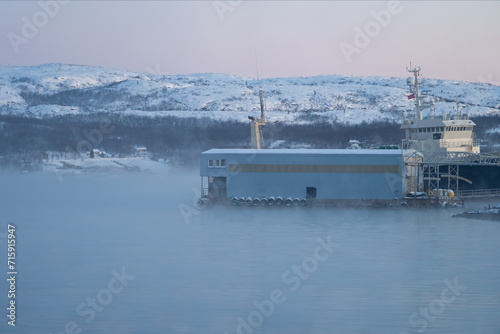 Vista de nave en el agua del mar en Kirkenes en Noruega tras el que hay un barco photo