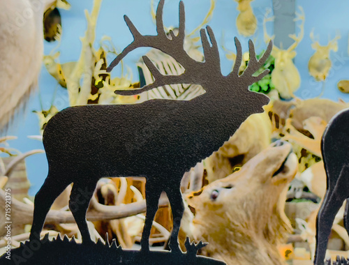 Canvas Print A silhouette of an elk statue with antlers is seen against abstract surreal background