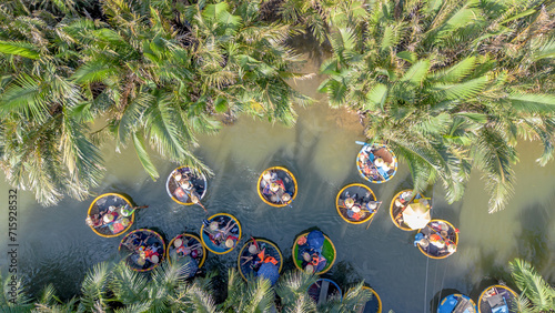 Aerial view of a coconut basket boat tour at the palms forest in Cam Thanh village, Hoi An, Vietnam. Tourists having an excursion in Thu Bon river photo