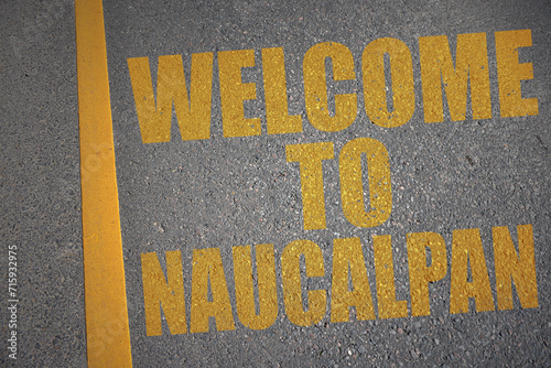 asphalt road with text welcome to Naucalpan near yellow line. photo