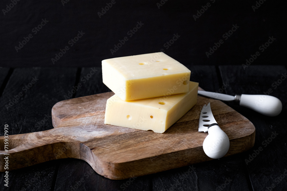 Piece of hard cheese on a wooden board