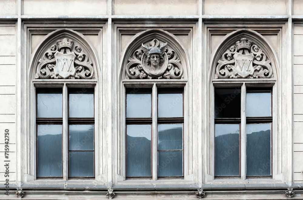 Fototapeta premium Old building facade with three windows with decorations