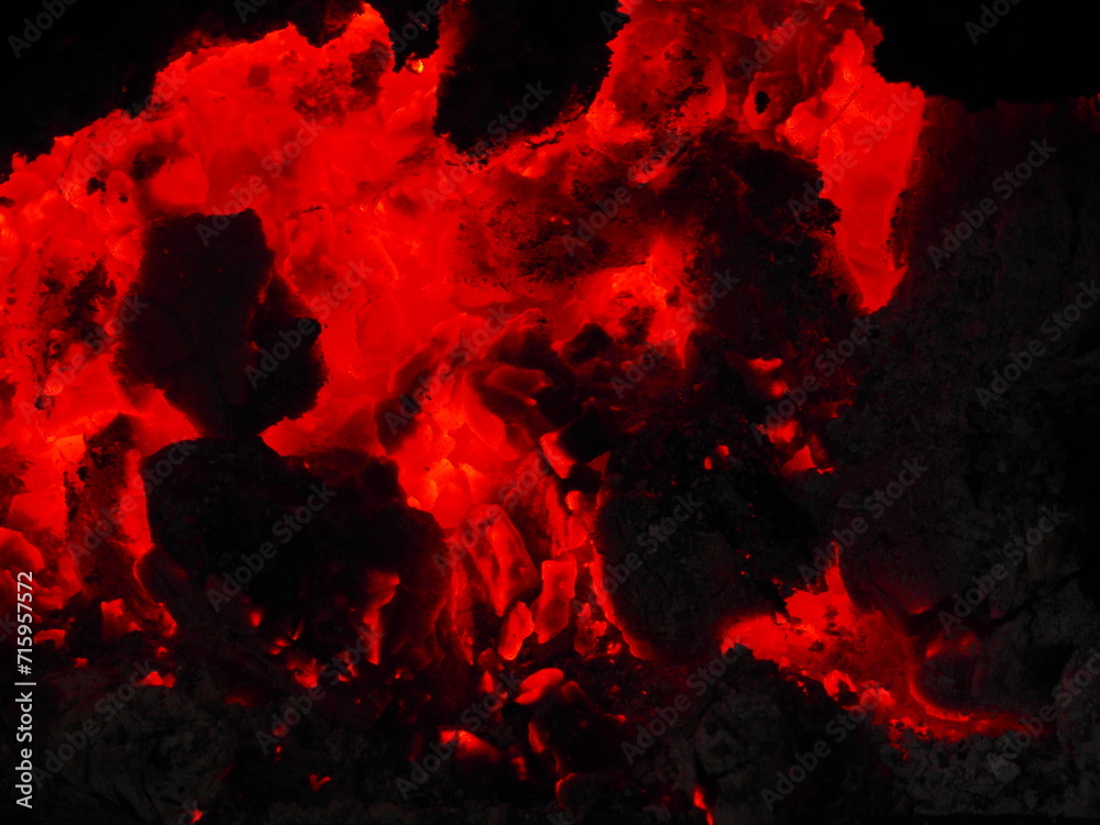 Fototapeta premium Reddish embers and bright orange flames in the winter bonfire.