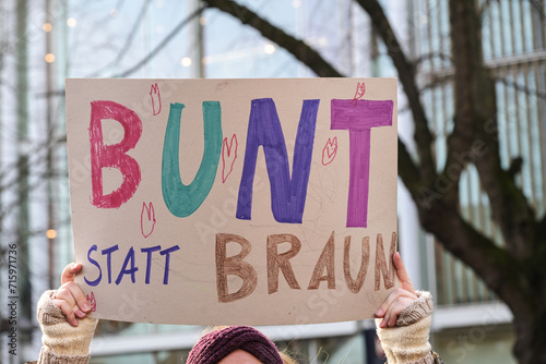 Woman holding a cardboard sign with the German text Bunt statt Braun (Colorful instead of Brown), as protest against racism and neo-Nazi fascism on a demonstration in Lubeck Germany, January 22, 2024 photo
