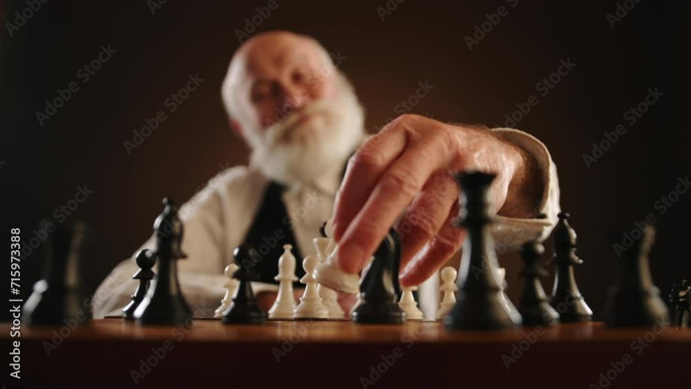An elderly man strokes his beard in thought, then strategically moves his knight, capturing the opponent's knight, and gestures invitingly for the next move. Camera 8K RAW. 