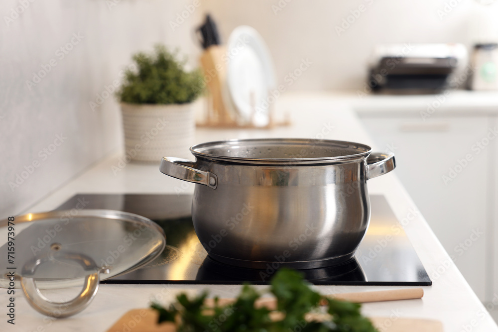 Pot with tasty soup on cooktop in kitchen Pot with tasty soup on cooktop in kitchen