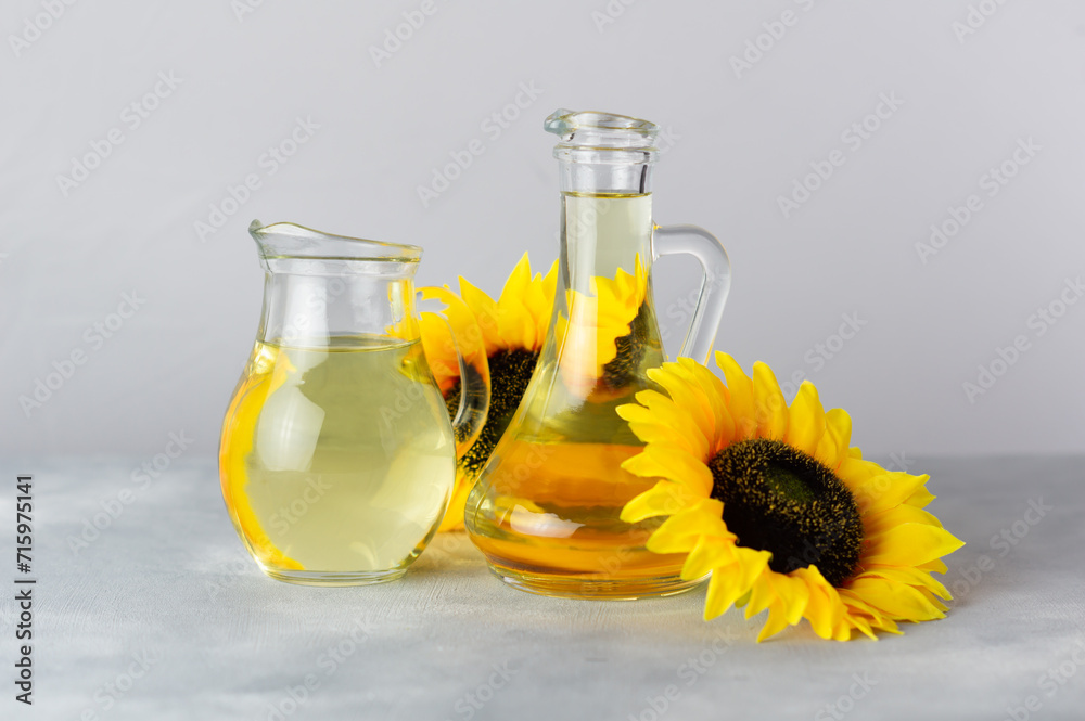 Glass bottle of sunflower seed oil with flowers on white rustic background, cooking oil, helianthus annuus Glass bottle of sunflower seed oil with flowers on white rustic background, cooking oil, helianthus annuus