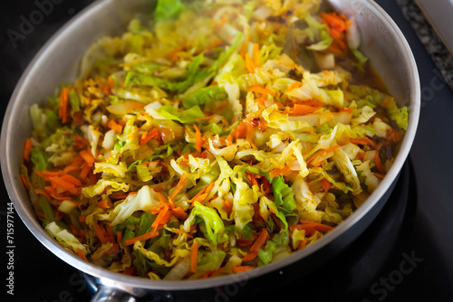 Preparing of chopped cabbage in pan. Braising fresh vegetables.