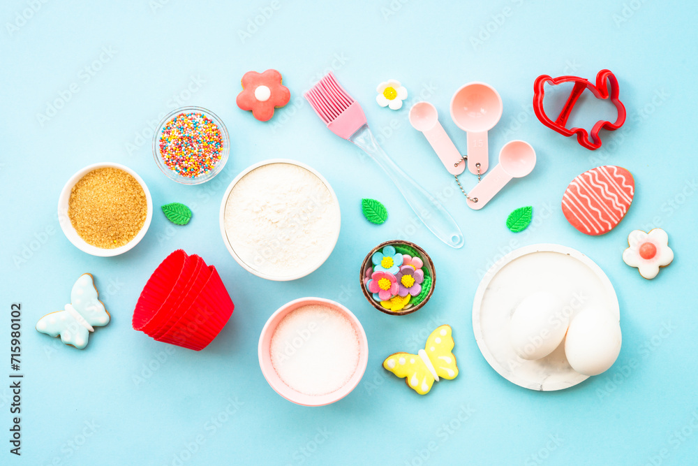 Easter baking background on blue. Flour, edds, sugar and gingerbread cookies. Top view with copy space. Easter baking background on blue. Flour, edds, sugar and gingerbread cookies. Top view with copy space.