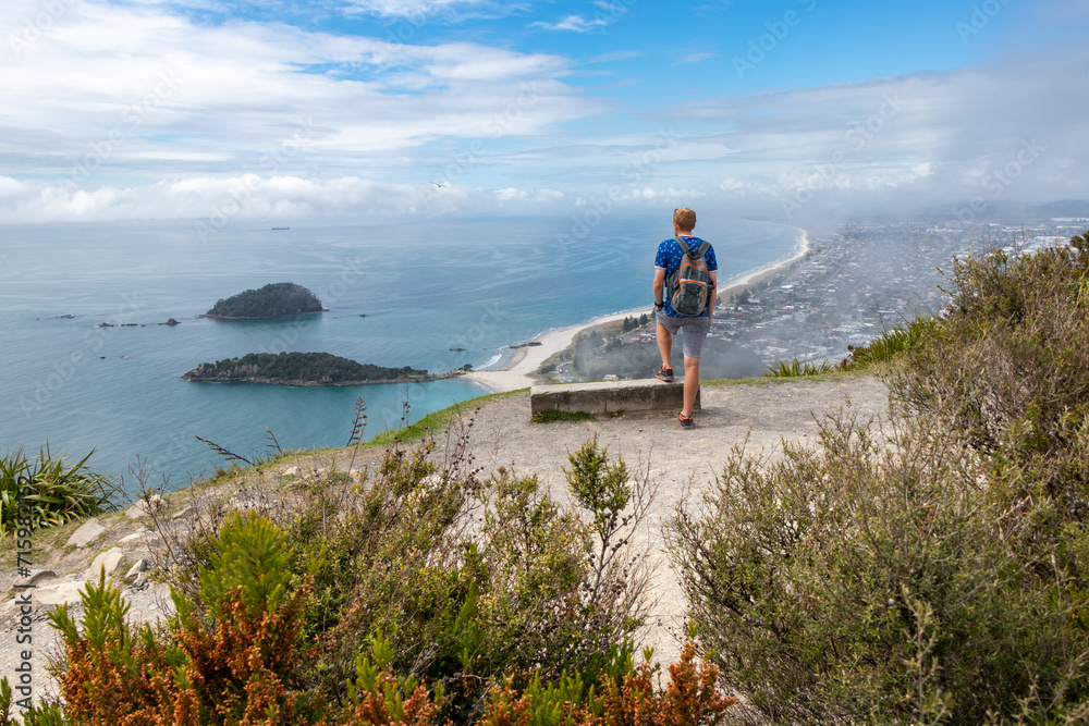 Young man looking out across Tauranga coastline from Mt. Maunganui - Tauranga, New Zealand