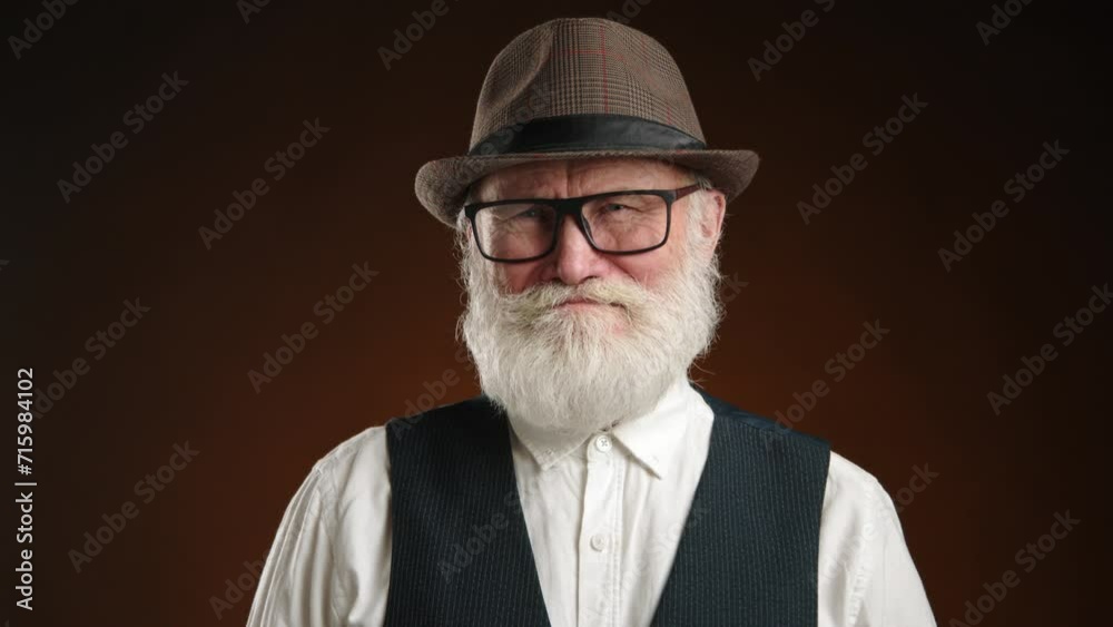 The composed elderly man with a white beard and glasses delivers a decisive nod of disapproval, set against an orange-hued backdrop. The composed elderly man with a white beard and glasses delivers a decisive nod of disapproval, set against an orange-hued backdrop.