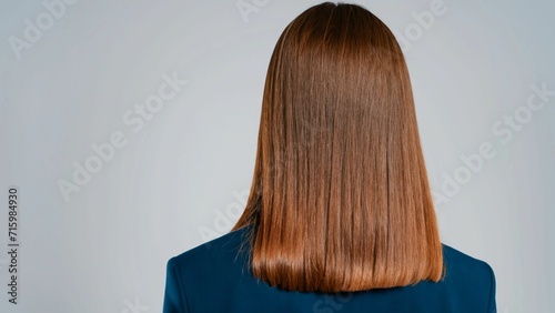 business woman with long  straight and beautiful brown hair. Hair care at home. Businesswoman looking at blue colored wall  Business happy new year 2024 cover concept.