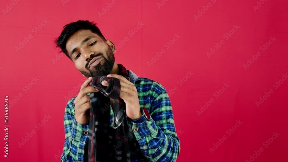 Smiling man in plaid shirt posing against a vibrant red background side view with copy space Smiling man in plaid shirt posing against a vibrant red background side view with copy space