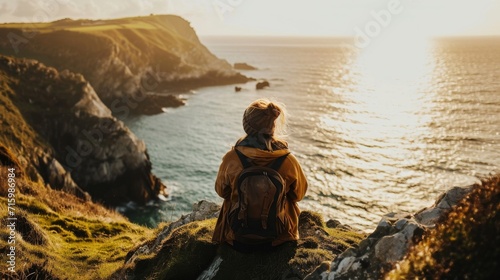 Person stood on a cliff overlooking the sea