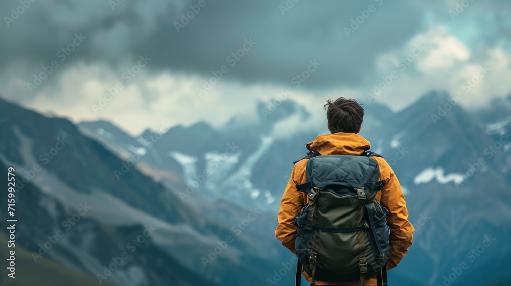 A rugged mountaineer stands in awe, gazing at the majestic mountain range ahead, clad in a sturdy backpack and jacket, ready to conquer the summit A rugged mountaineer stands in awe, gazing at the majestic mountain range ahead, clad in a sturdy backpack and jacket, ready to conquer the summit