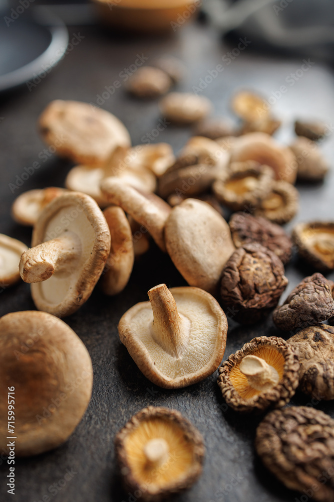The fresh and dried shiitake mashrooms on black table. The fresh and dried shiitake mashrooms on black table.