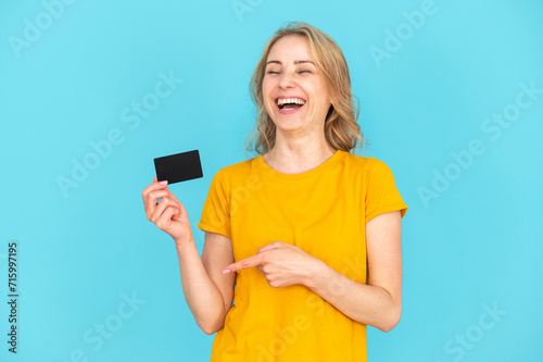 Happy woman pointing at bank card with amazing and easy customer service photo