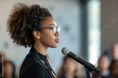Woman With Glasses Speaking Into Microphone photo