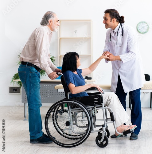 Old couple visiting young male doctor