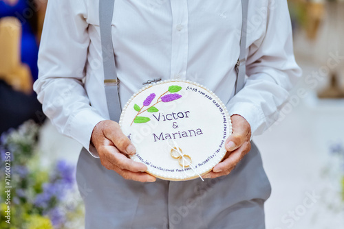a ring holder decorated with the names   Victor   Mariana  embroidered