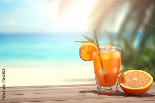 Glass of orange juice on a beachside table with sea backdrop