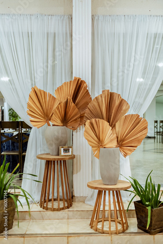 two wooden stools with white porcelain vases and natural leaves decorating