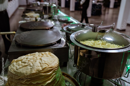 a waiter preparing crepes at a buffet table