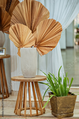 two wooden stools with white porcelain vases and natural leaves decorating