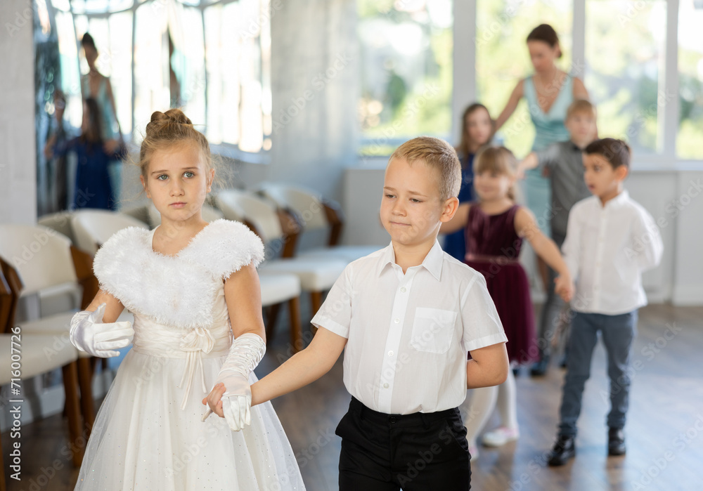 Obraz premium Active preteen children practicing ballroom dances in pairs during dancing classes