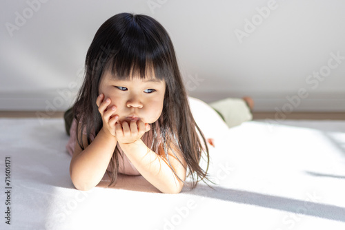 寝転がる不機嫌な女の子の様子（3歳、日本人） photo