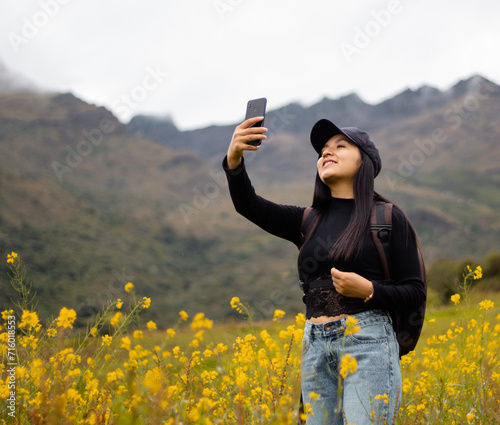 Una chica turista con mochila y celular tomandose un selfie en el paraíso floral, Encanto primaveral, tecnología y flores amarillas en armonía.