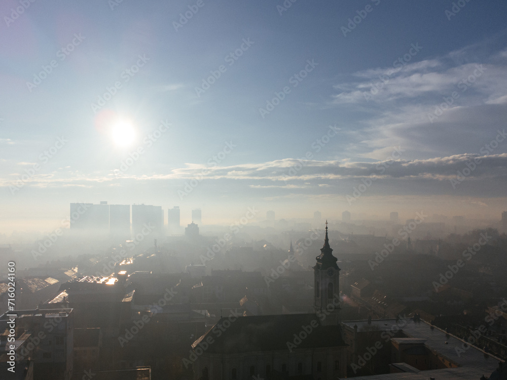 Drone aerial view of Belgrade city in the smog and fog in the morning. Zemun and New Belgrade district, Serbia, Europe.