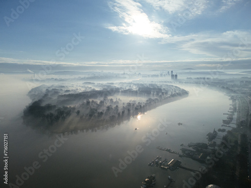 Drone flight above the Danube river in the smog and fog in the morning. Zemun and New Belgrade district, Belgrade, Serbia, Europe. © lightscience