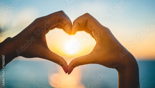 female hands create a heart shape against the radiant sky  symbolizing love  unity  and connection with the sun s warmth and positive energy