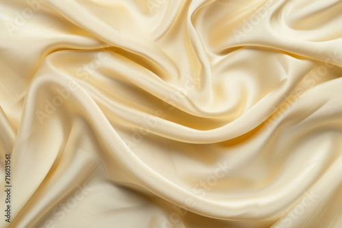 Soft creamy satin fabric with elegant waves and folds in a close-up view.