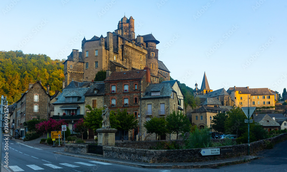 Scenic landscape of French village of Estaing on bank of Lot river with medieval Chateau