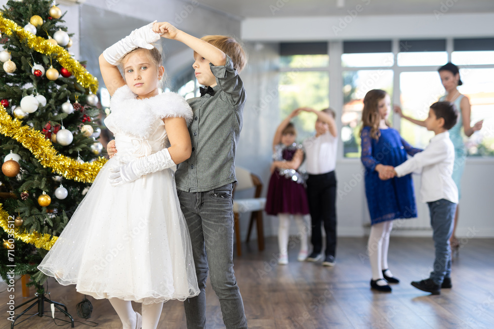 Viennese waltz performed by beautifully dressed children near the Christmas tree