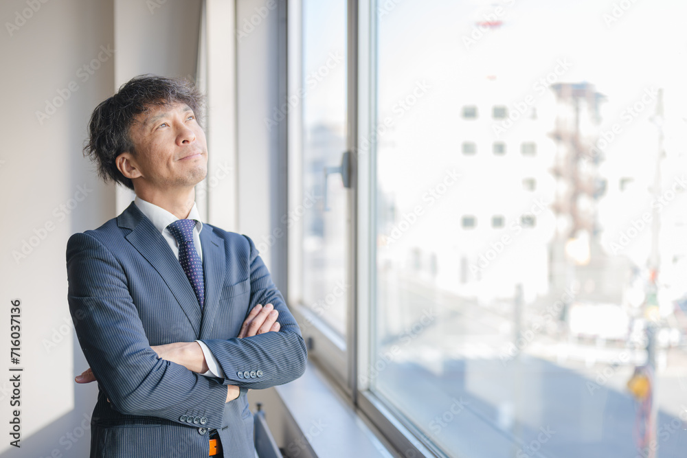 かっこよく腕を組むミドル男性