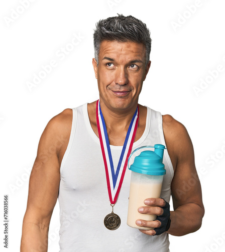 Athletic Hispanic with protein and gold medal dreaming of achieving goals and purposes