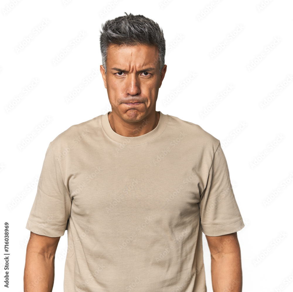 Middle-aged Latino man blows cheeks, has tired expression. Facial expression concept. Middle-aged Latino man blows cheeks, has tired expression. Facial expression concept.
