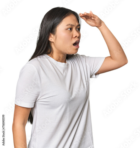 Young chinese woman isolated looking far away keeping hand on forehead.