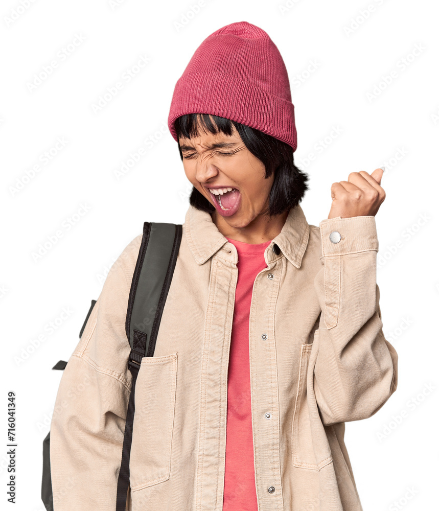 Young student with backpack and beanie in studio showing a disappointment gesture with forefinger. Young student with backpack and beanie in studio showing a disappointment gesture with forefinger.