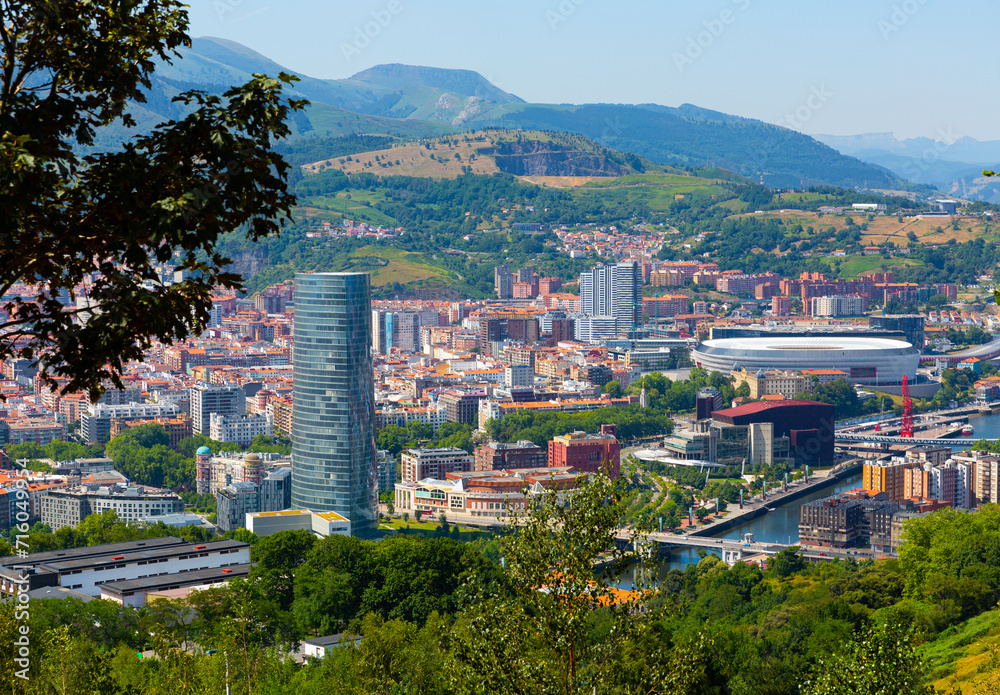 General view of Spanish city of Bilbao on background of picturesque mountain landscape in sunny summer day..