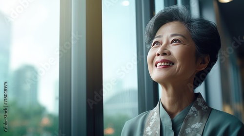 Asian senior business woman looking at the window
