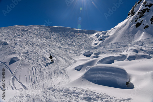 Skiing downhill off piste on the amazing sunny day with fresh snow at the Meribel ski resort in France.