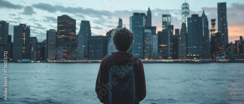 Contemplative Young Adult Observing the Urban Skyline at Dusk, a Symbol of Dreams and Aspirations © Alienmonster Images