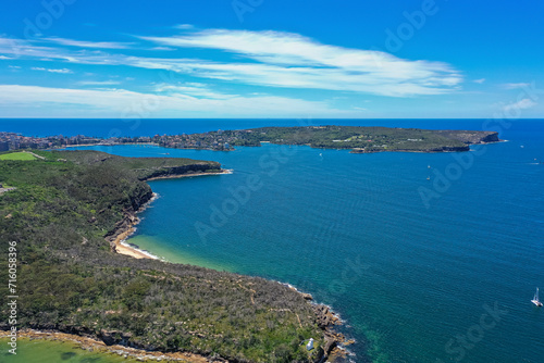 High angle aerial drone view of Grotto Point and Washaway Beach in the suburb of Clontarf, Sydney, New South Wales, Australia. Manly and North Head in the background.