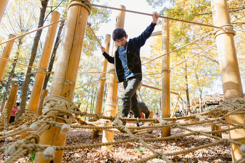 Boy walking on a rope play structure