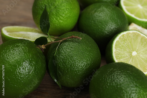 Fresh limes and leaves on table, closeup
